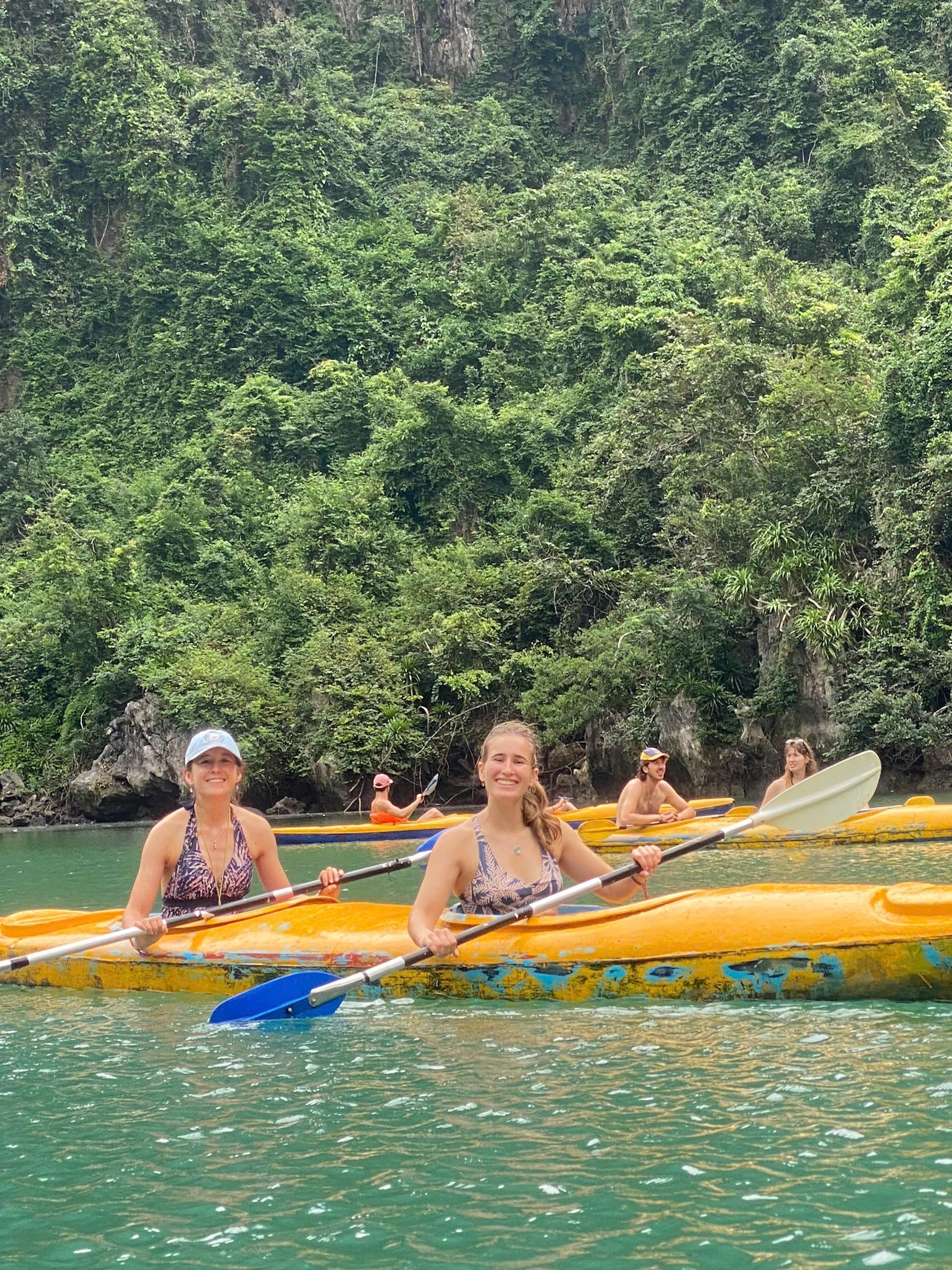 Kayaking beside forested limestone cliffs