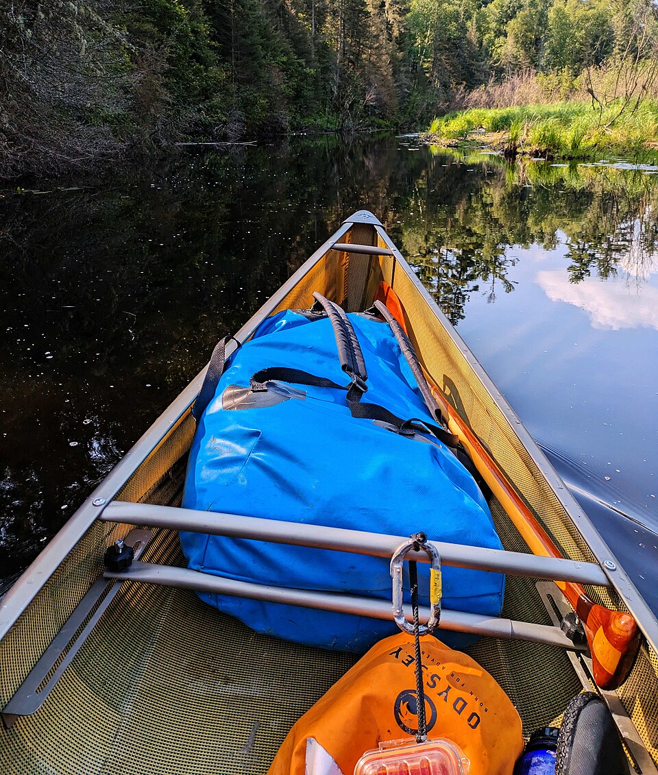 Blue secured dry bag in the bow of a canoe