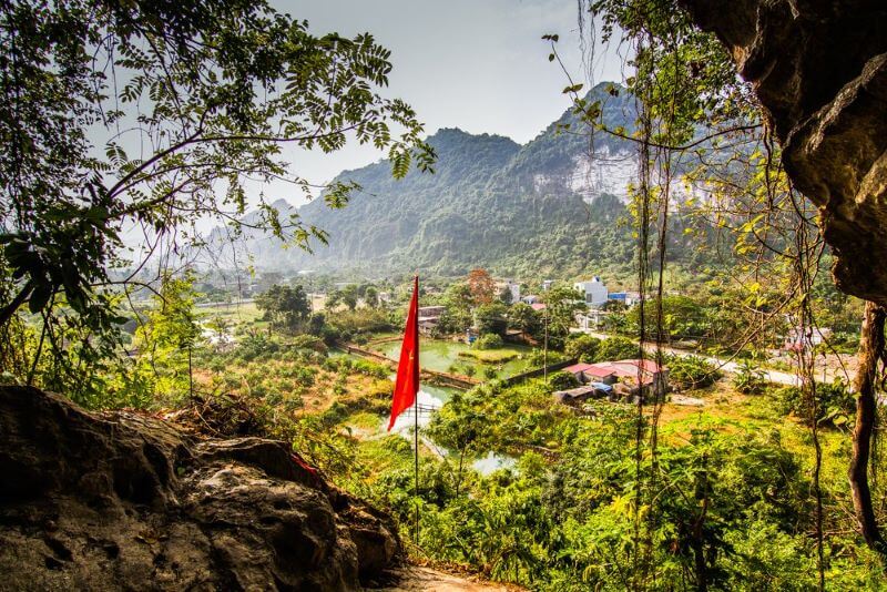 View from a cave entrance across a green valley on Cat Ba