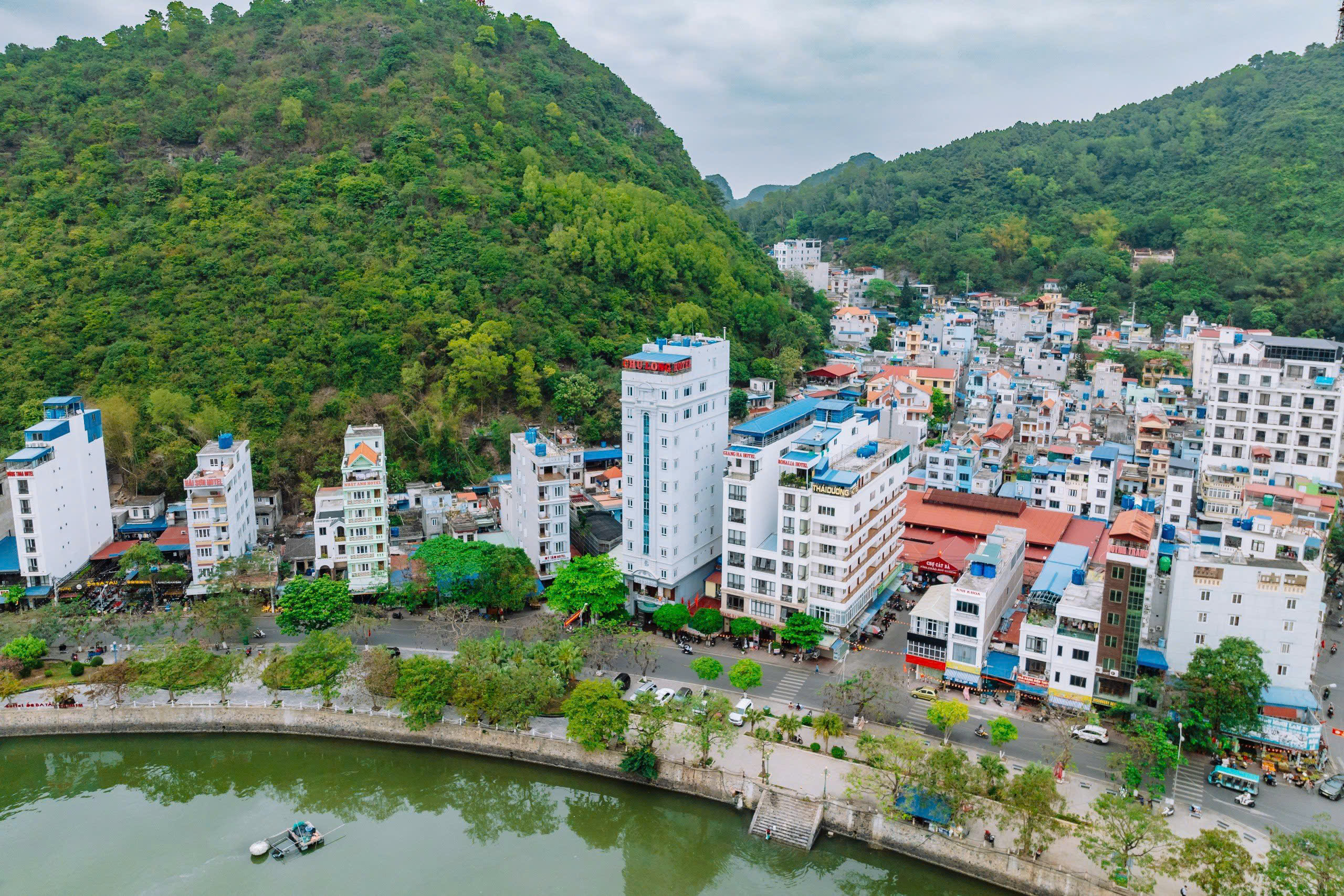 Cat Ba waterfront with hotels and forested hills