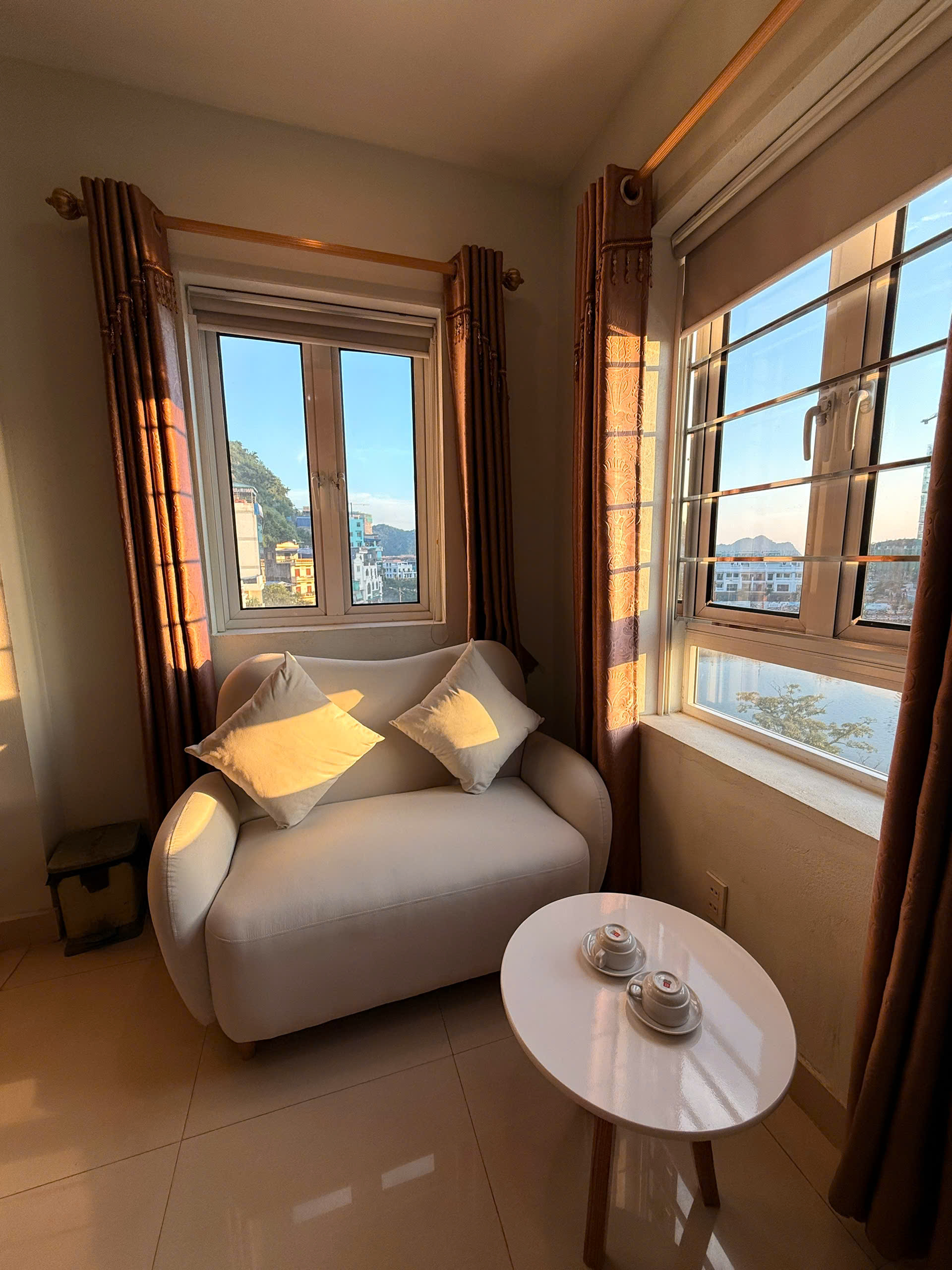 Hotel room sitting area beside windows overlooking Cat Ba Town