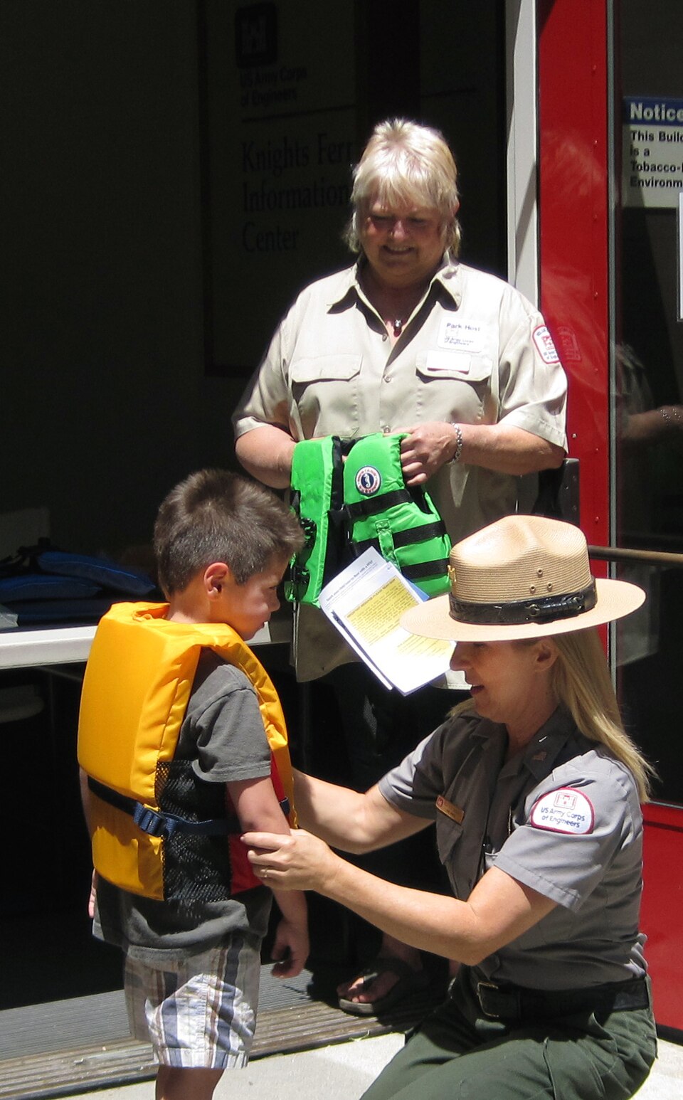 Park ranger checking a child’s life jacket fit