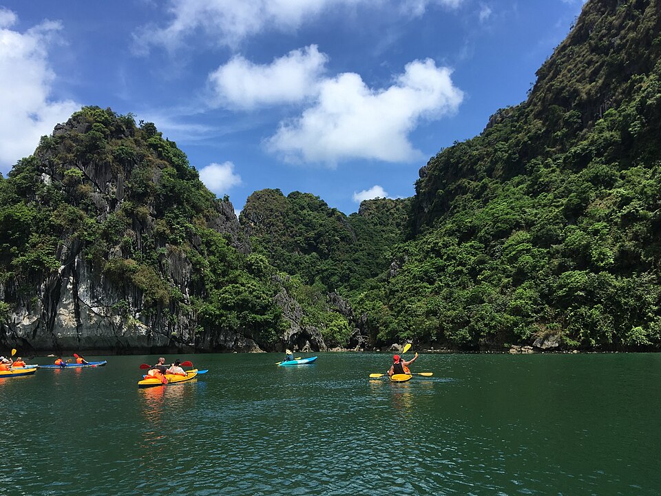 Kayakers in sunny Ha Long Bay wearing flotation vests