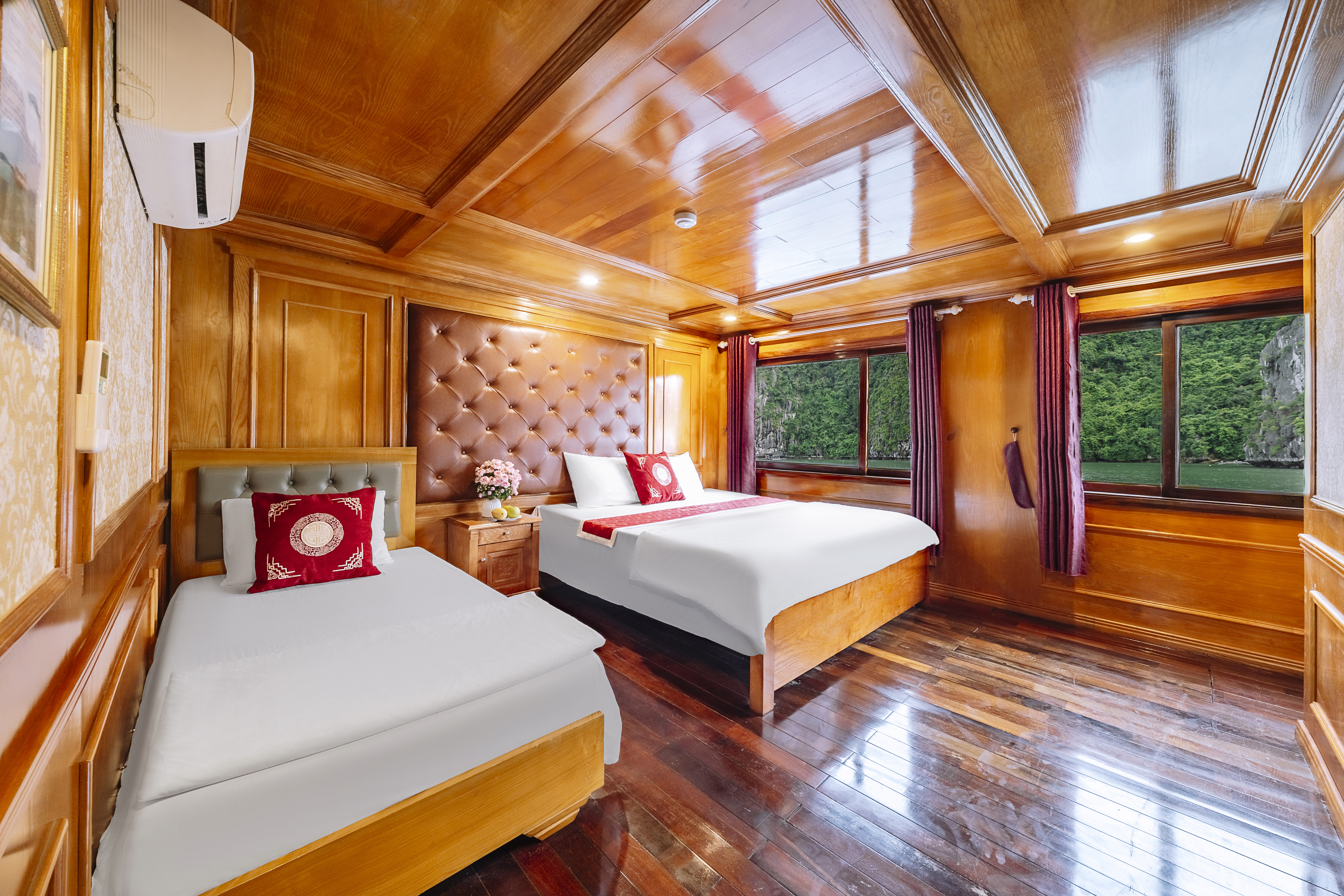 Wood-lined example cruise cabin with two beds and bay-facing windows