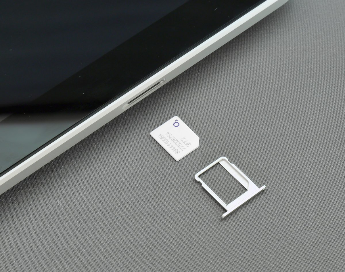 SIM card and tray beside a smartphone