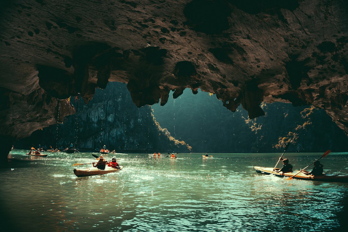 Kayaks beneath a limestone cave roof in Ha Long Bay